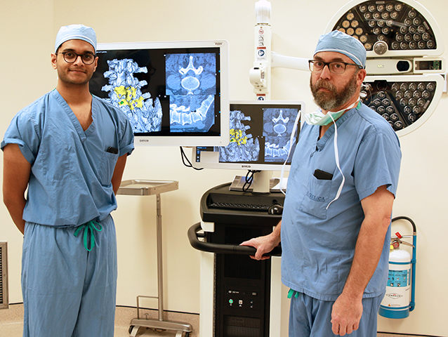 -	Schrynel D’Mello, a clinical engineer with 7D Surgical and Dr. Matthew Philips of the Spinal Surgery team at St. Luke’s Hospital get a better look at a patient’s anatomy with 7D Surgical Machine-vision Image Guided Surgery technology.