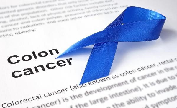 blue ribbon over printed paper with the words colon cancer