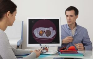 lung image on a pc with a middle aged man in the background