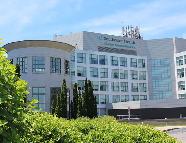 Southcoast Health Charlton Memorial Hospital, a modern medical facility with a large multi-story building surrounded by greenery.